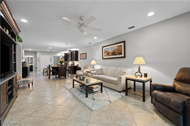 living room with ceiling fan with notable chandelier and light tile patterned floors