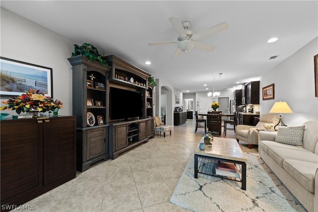 living room featuring light tile patterned floors and ceiling fan with notable chandelier