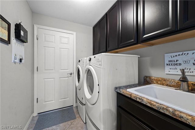 washroom featuring separate washer and dryer, sink, light tile patterned floors, and cabinets