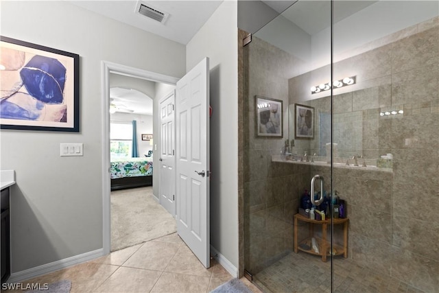 bathroom featuring tile patterned floors, ceiling fan, a shower with door, and vanity