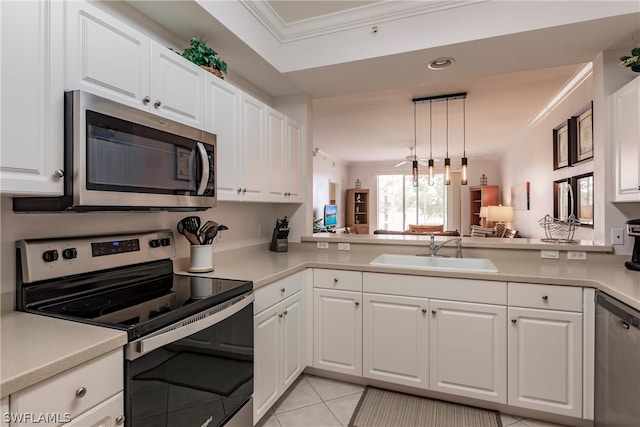 kitchen featuring crown molding, white cabinets, appliances with stainless steel finishes, sink, and hanging light fixtures