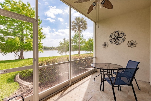 sunroom / solarium with ceiling fan, a water view, and a wealth of natural light