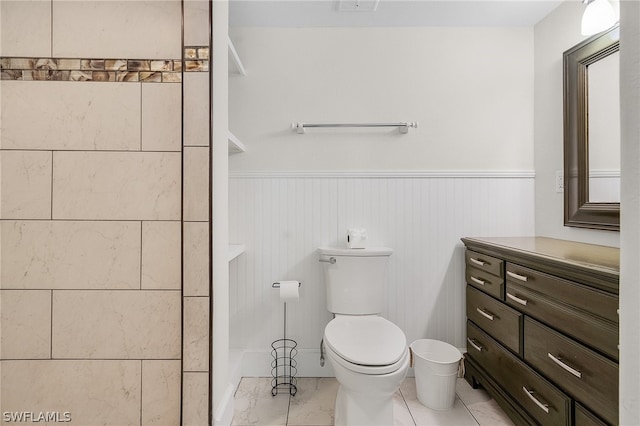 bathroom featuring tile flooring, toilet, and vanity