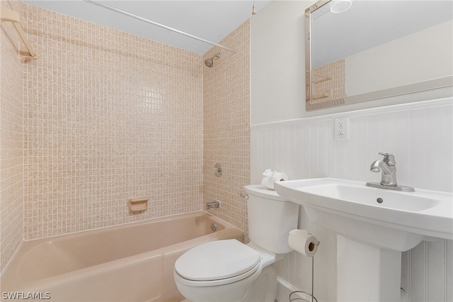 bathroom with toilet and tiled shower / bath combo