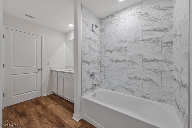 bathroom featuring tiled shower / bath combo, hardwood / wood-style floors, and vanity