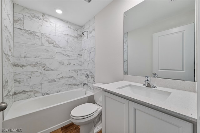 full bathroom featuring toilet, wood-type flooring, vanity, and tiled shower / bath