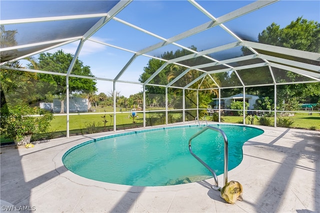 view of swimming pool with a patio area, a lanai, and a lawn