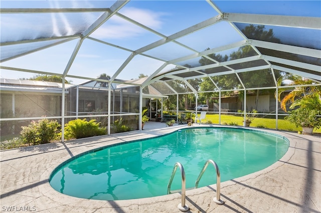 view of swimming pool with glass enclosure, a lawn, and a patio area