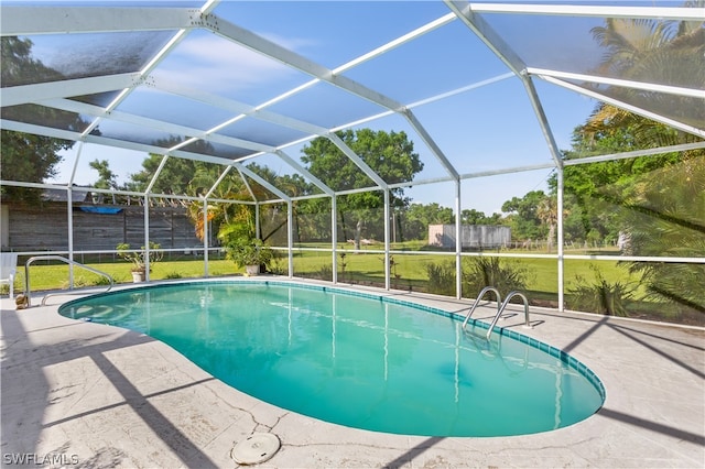 view of swimming pool with a patio area, a yard, and a lanai