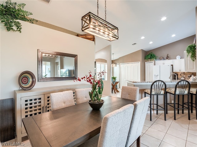 dining space with vaulted ceiling and light tile floors