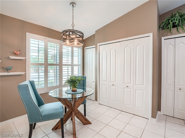 dining room featuring lofted ceiling, plenty of natural light, and light tile floors