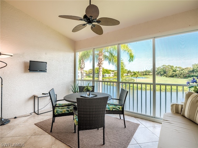 sunroom / solarium featuring ceiling fan and a water view