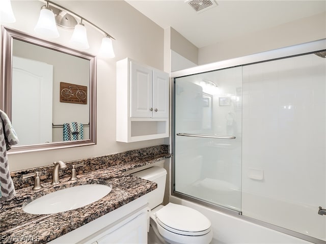 full bathroom featuring vanity, toilet, and bath / shower combo with glass door