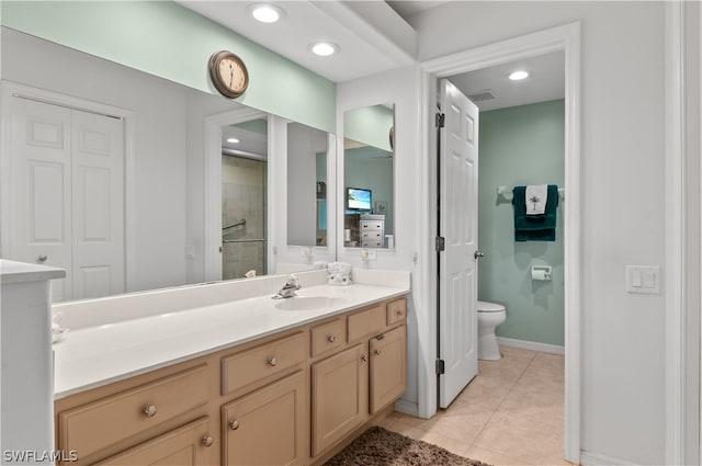 bathroom with toilet, vanity, and tile patterned flooring