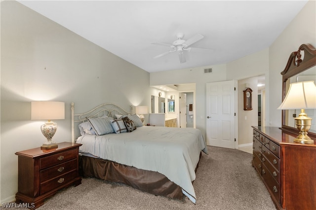 bedroom featuring connected bathroom, light carpet, and ceiling fan