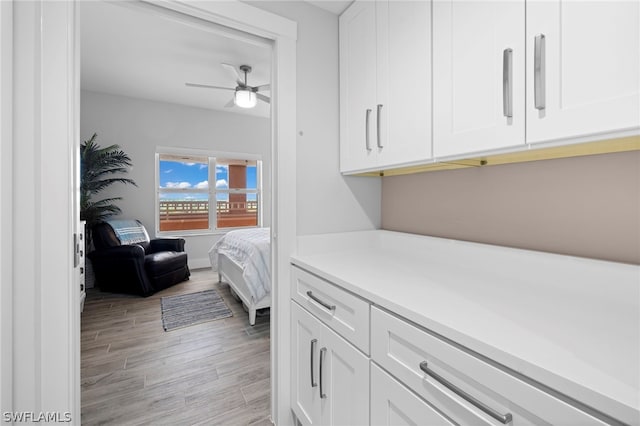 interior space with ceiling fan, white cabinetry, and light hardwood / wood-style flooring