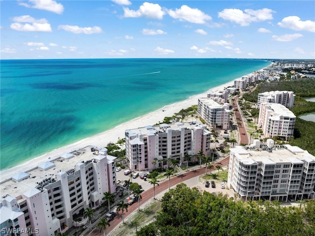 birds eye view of property featuring a water view and a beach view