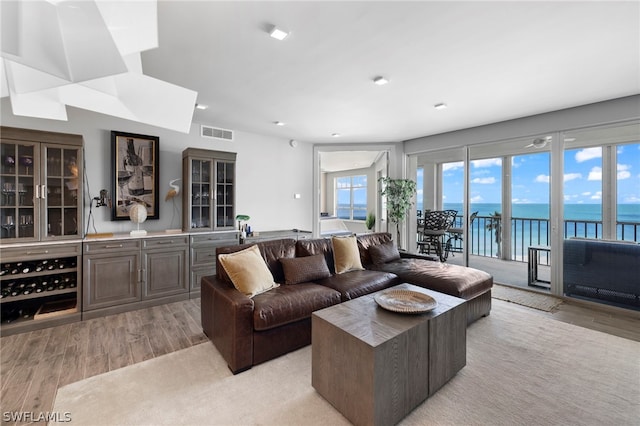 living room with a water view and light hardwood / wood-style floors