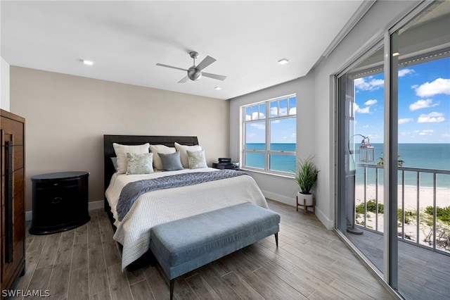 bedroom featuring ceiling fan, a water view, light wood-type flooring, and access to outside