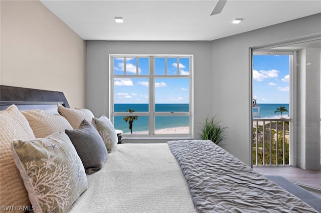 bedroom with ceiling fan, a water view, and hardwood / wood-style flooring