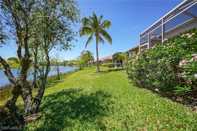 view of yard featuring a lanai and a water view