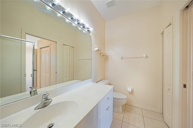 bathroom with vanity with extensive cabinet space, toilet, and tile floors