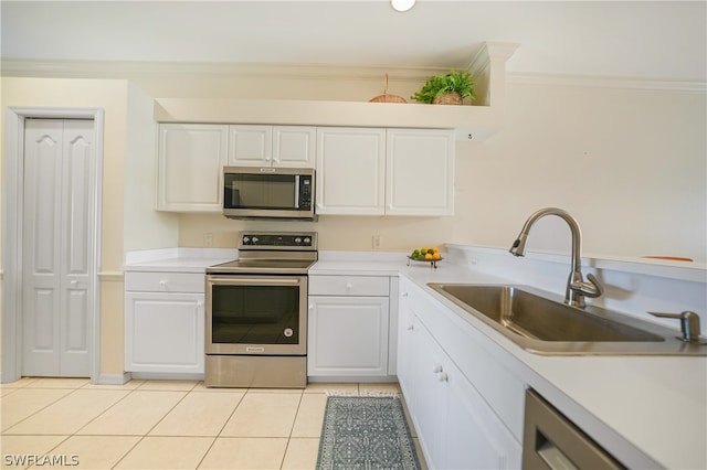 kitchen featuring sink, white cabinetry, stainless steel appliances, and light tile floors