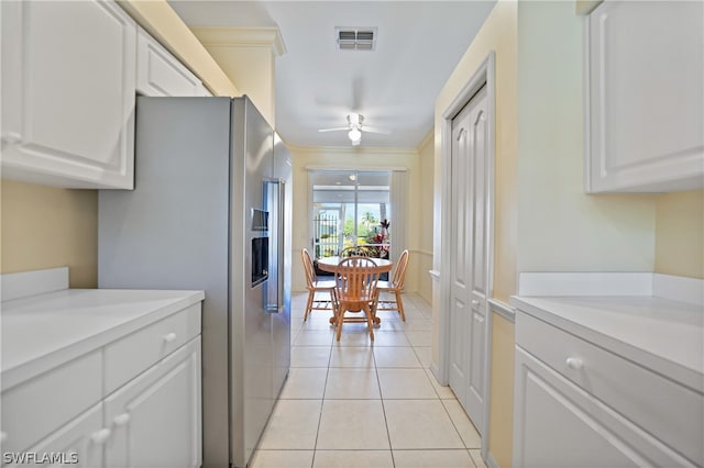 kitchen featuring high quality fridge, ceiling fan, white cabinetry, and light tile floors