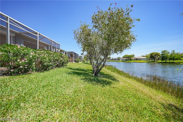 view of yard featuring a water view and glass enclosure