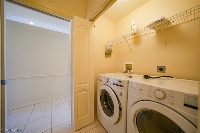 washroom with washer hookup, hookup for an electric dryer, washing machine and dryer, and light tile floors