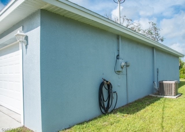 view of side of property featuring central AC unit and a lawn