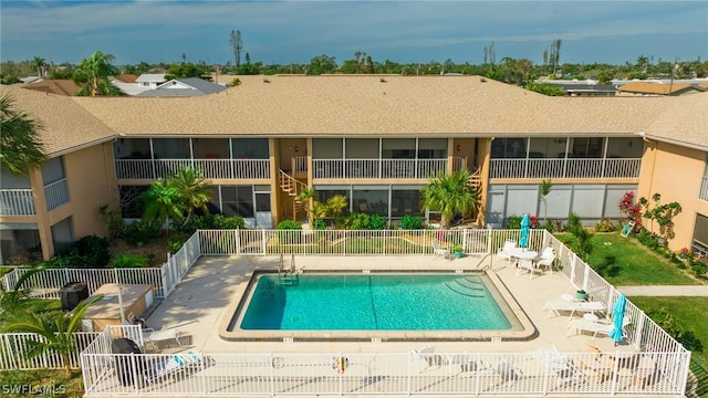 community pool with a patio and fence