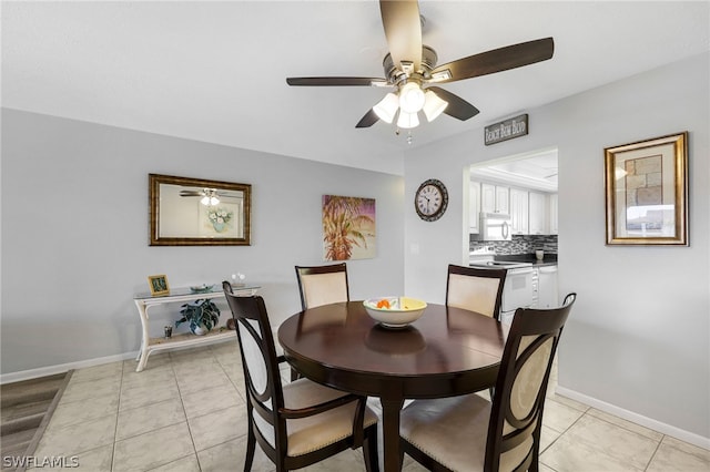 dining space featuring light tile patterned flooring, baseboards, and ceiling fan