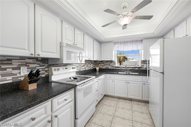 kitchen featuring white appliances, a tray ceiling, sink, light tile patterned floors, and white cabinetry