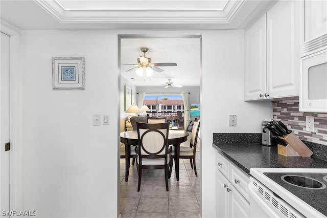 kitchen with white appliances, a ceiling fan, white cabinetry, dark countertops, and tasteful backsplash