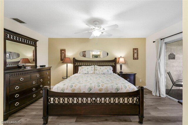 bedroom featuring visible vents, baseboards, wood finished floors, and a ceiling fan