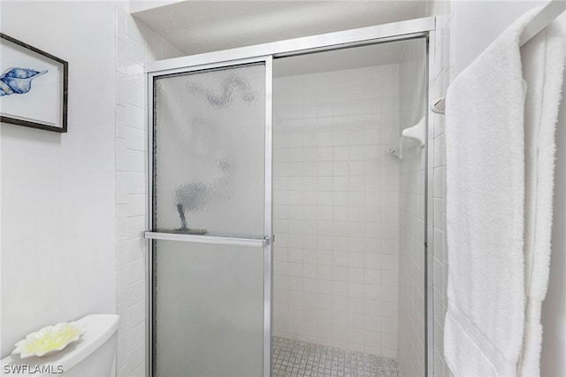 bathroom with an enclosed shower and toilet