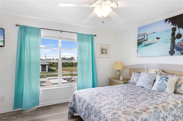 bedroom with ceiling fan, baseboards, and wood finished floors