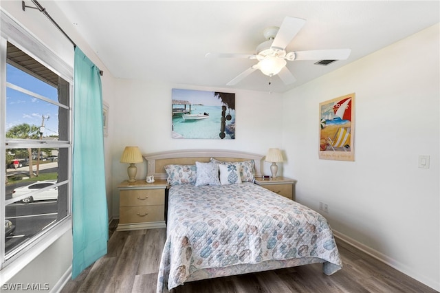 bedroom with visible vents, baseboards, wood finished floors, and a ceiling fan