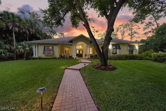 ranch-style home featuring a lawn