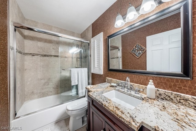 full bathroom with shower / bath combination with glass door, vanity, and toilet