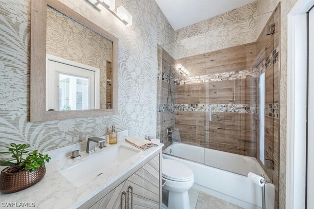 full bathroom with vanity, toilet, and combined bath / shower with glass door