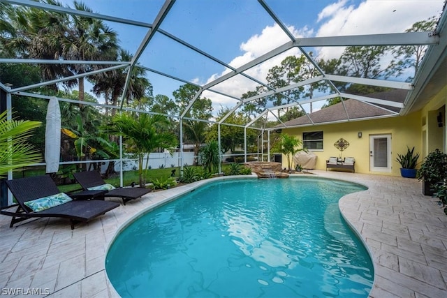 view of swimming pool featuring glass enclosure and a patio