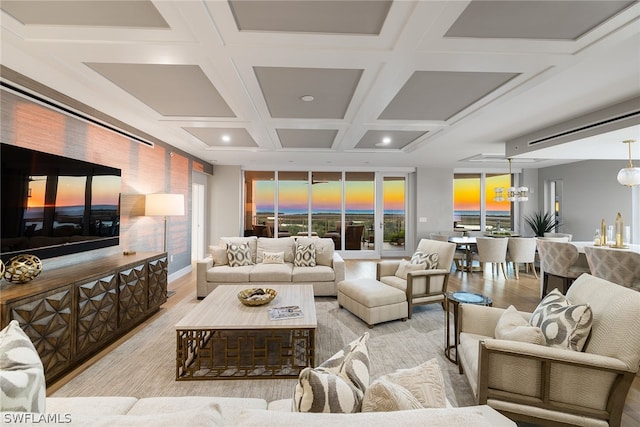 living room with beam ceiling, coffered ceiling, and an inviting chandelier