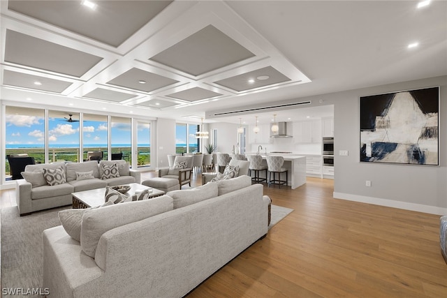 living room featuring sink, coffered ceiling, and light hardwood / wood-style flooring