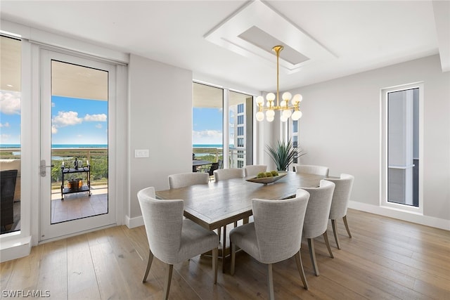 dining space featuring light wood-type flooring and a chandelier