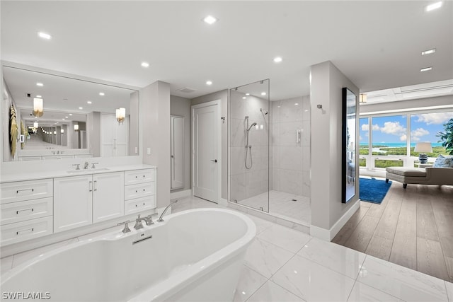 bathroom featuring plus walk in shower, tile flooring, and vanity