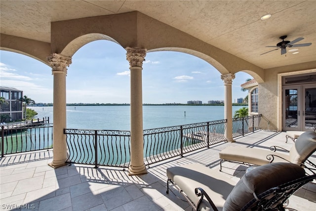 view of patio / terrace featuring a balcony, ceiling fan, and a water view