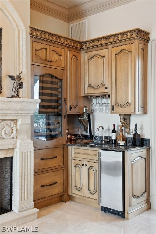 kitchen featuring refrigerator, crown molding, dark stone counters, and light tile flooring