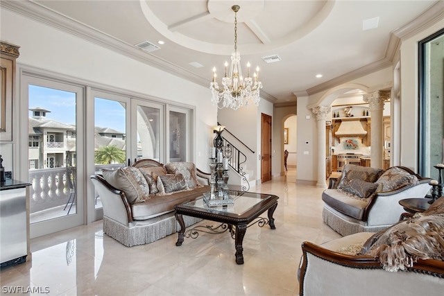 tiled living room featuring crown molding, decorative columns, a notable chandelier, and a raised ceiling